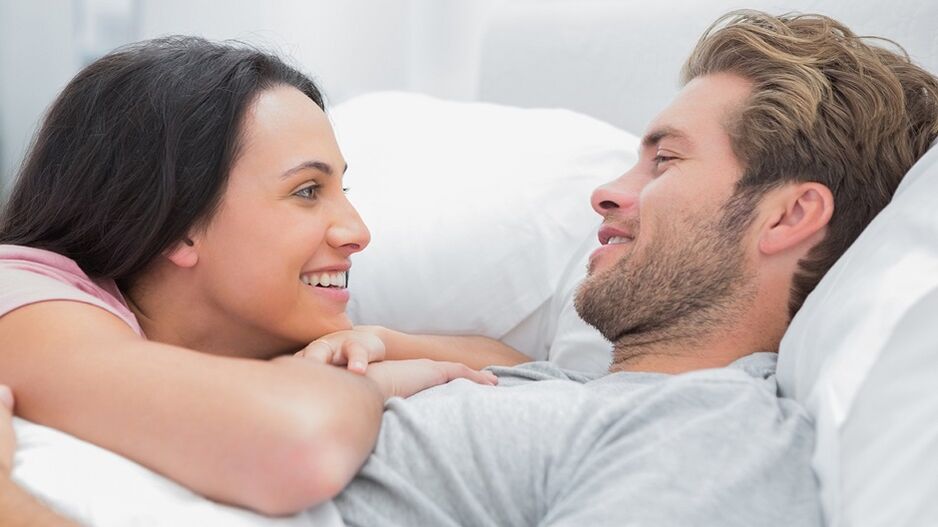 Щастлива жена с мъж в леглото